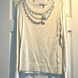 White soft blouse with pearl detailing.